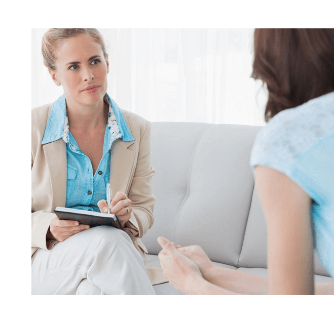 A woman sitting on the couch talking to another person.