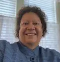 A woman with curly hair and a blue shirt.