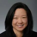 A woman with long black hair smiles for the camera.