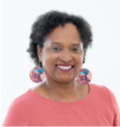 A woman with big earrings smiles for the camera.